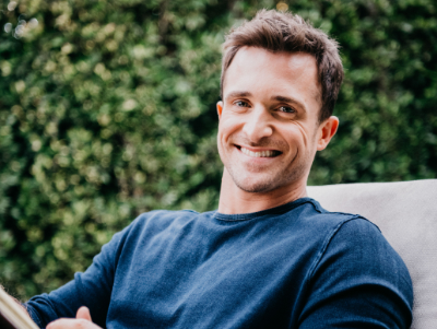 A photograph of Matthew Hussey sitting outside