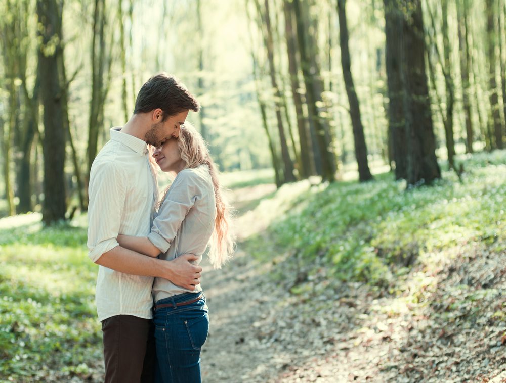man hugging woman in forest